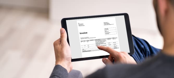 invocie processing on tablet with man holding the screen