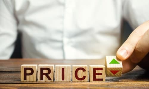 A man changes the position of a block with symbols of growth and decline near the word Price