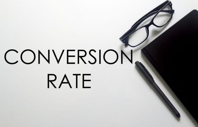 A glasses, notebook and pen with CONVERSION RATE written on white background