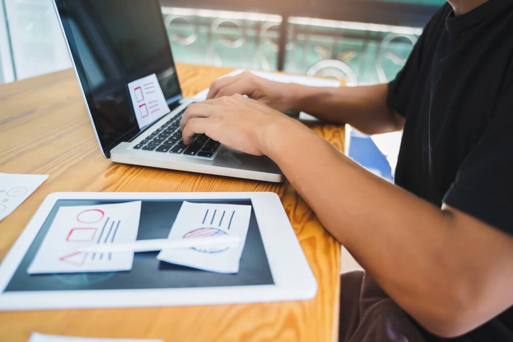 Web designer working laptop tablet user interface design